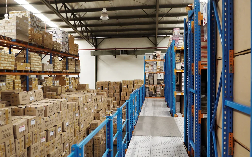 Active commercial warehouse with high storage racks and wide operating aisles.