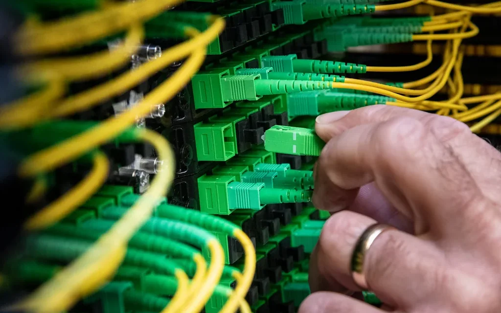 Technician inspecting network connections in a commercial rack.